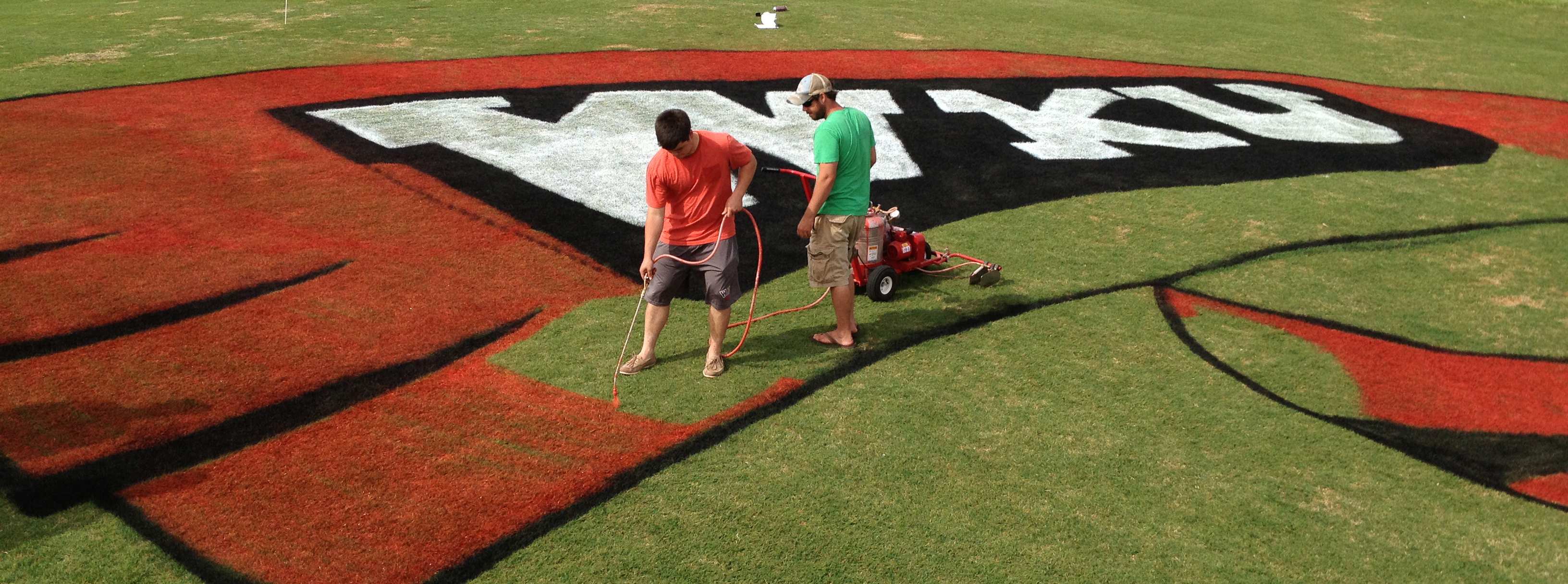 Students painting Red Towel on Turf Students painting Red Towel on Turf