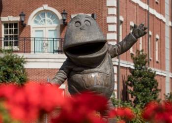 big red statue behind flowers