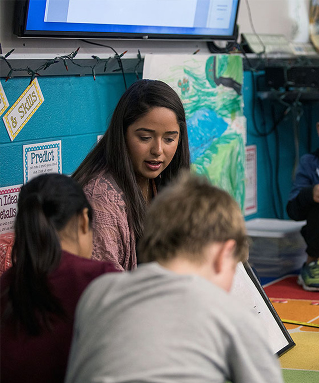 A student graduating during fall commencement with a degree in hand.