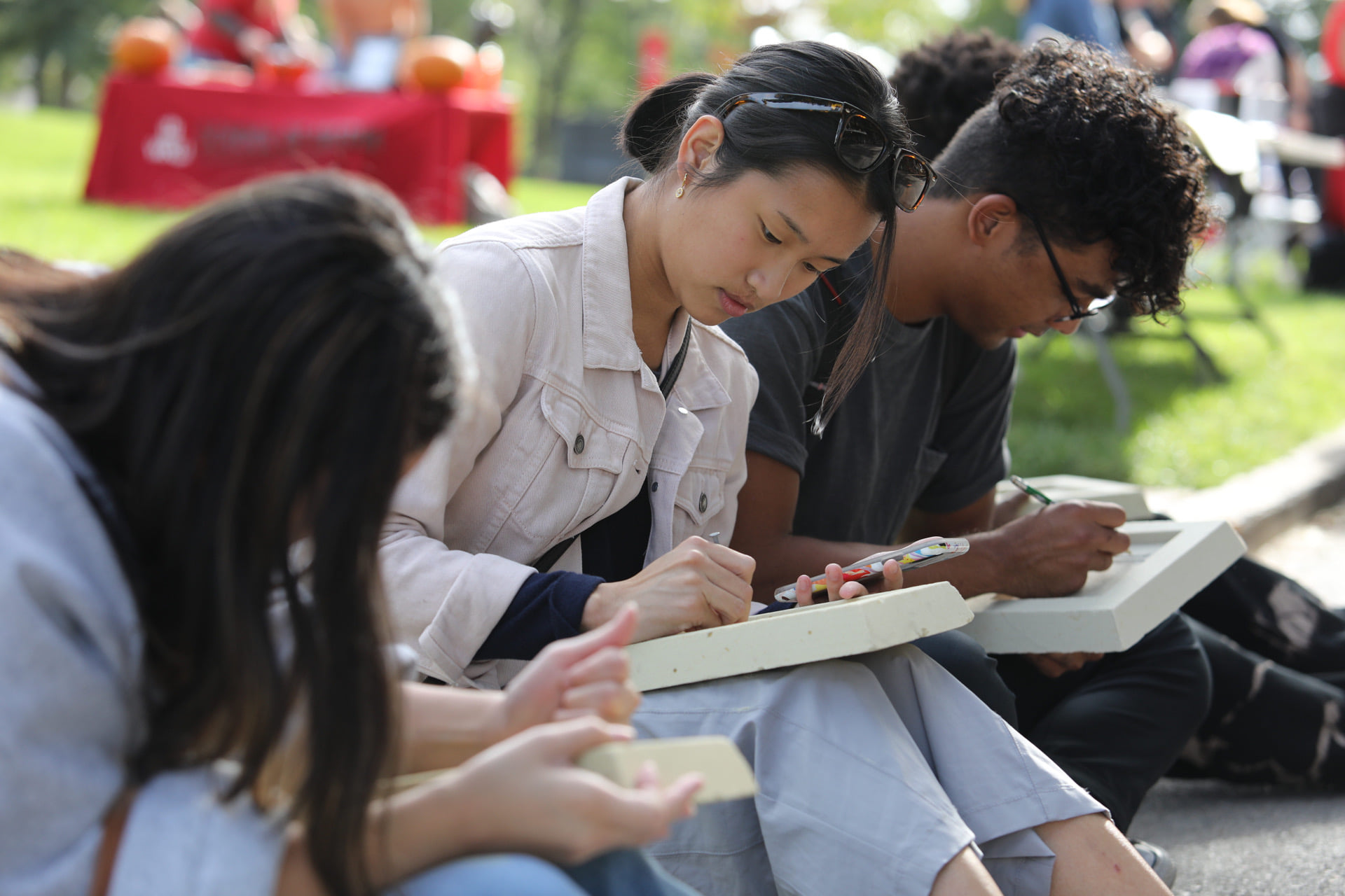 Group of students writing on tablets while outside