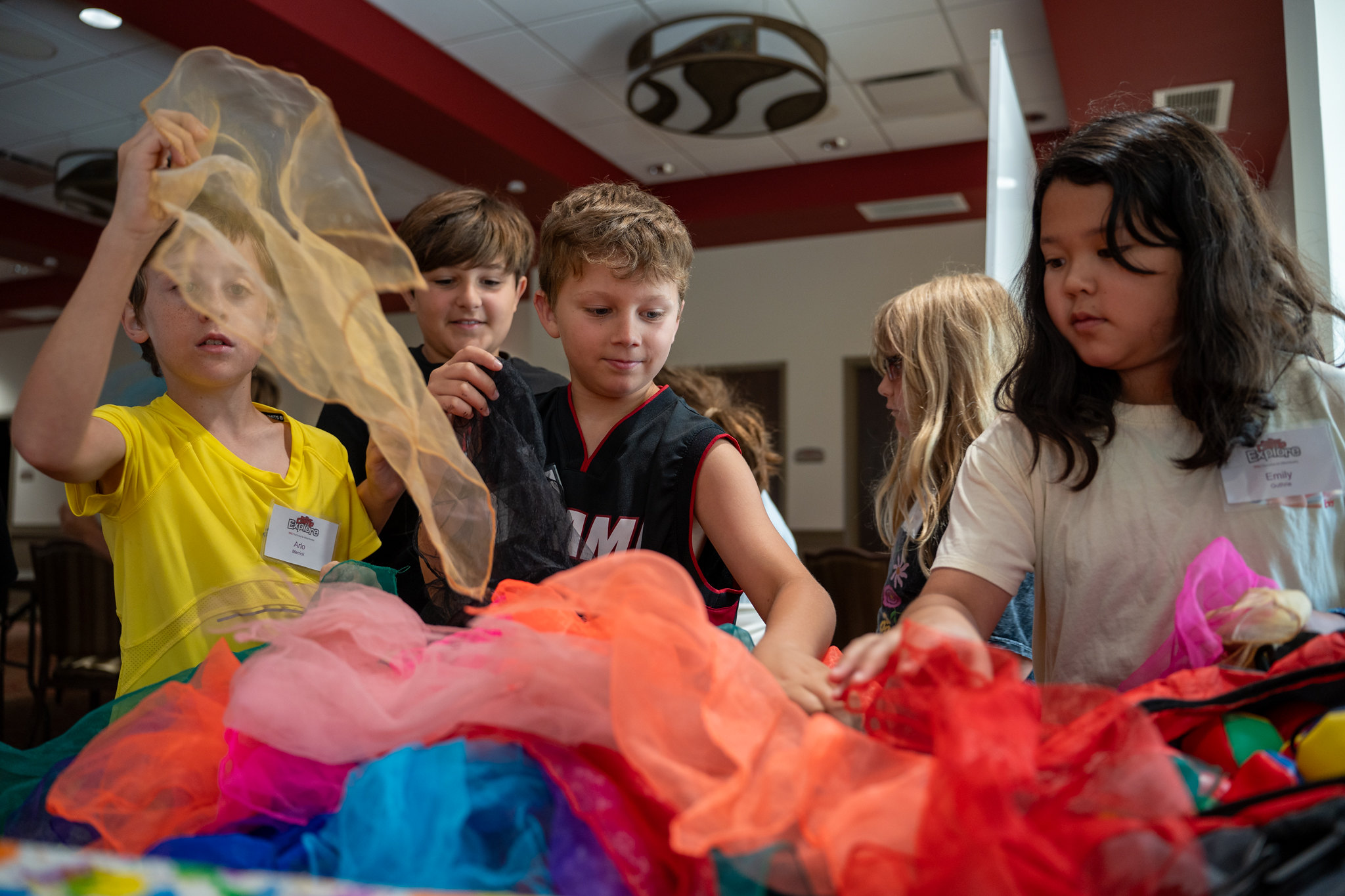children playing with multi-colored scarves