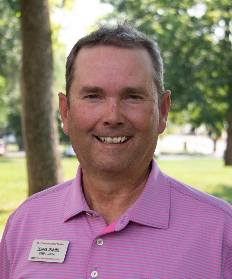 man in a red polo smiling at the camera