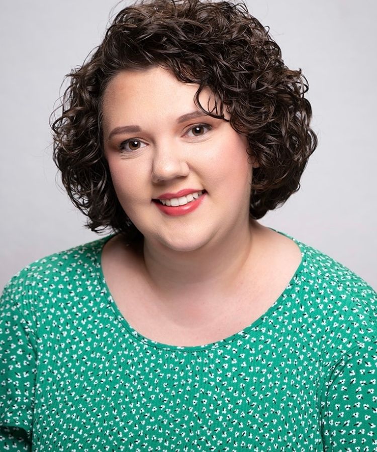 woman in green blouse smiling at camera
