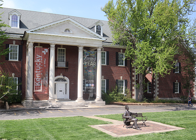 An outdoor view of the Kentucky Museum with a student walking by.
