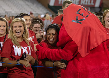 Big Red hugs a student at MASTER Plan