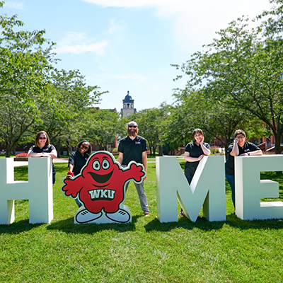 HOME sign with staff outside