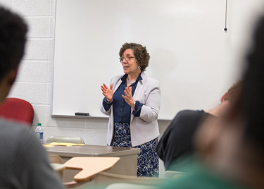 WKU faculty teaching a class in front of a white board