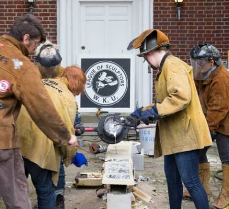 Sculptors pouring metal