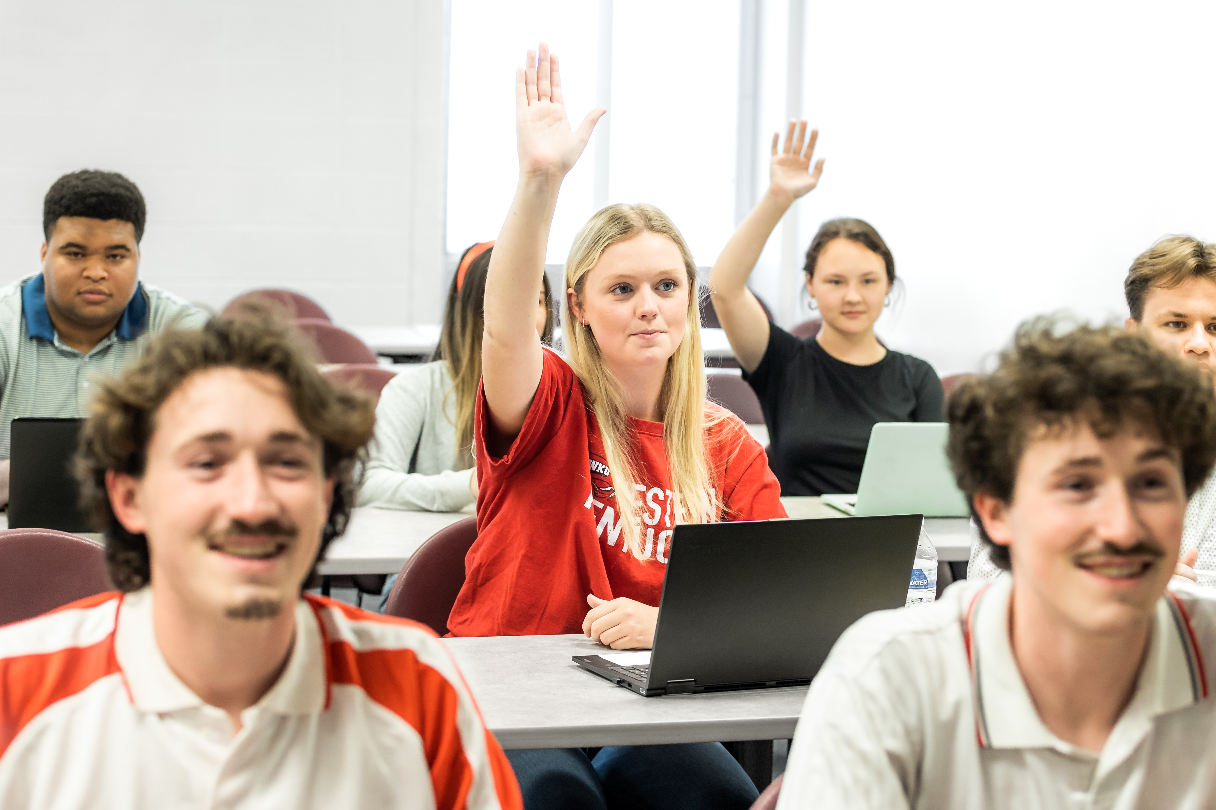 A Western Kentucky University student raises her hand in class.