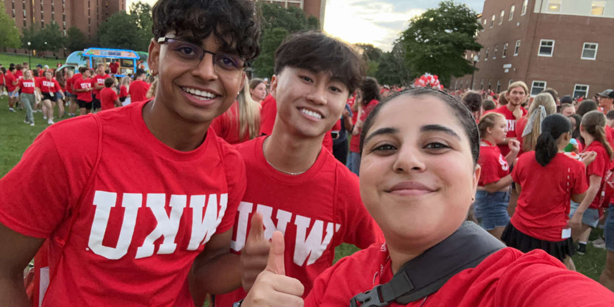 students smiling for group selfie