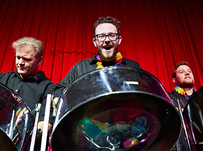 3 people playing steel drums