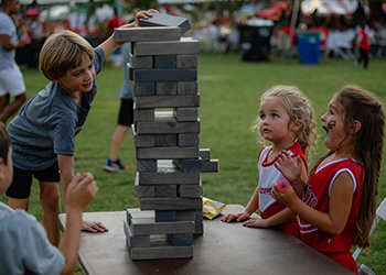 Kids playing Jenga on South Lawn