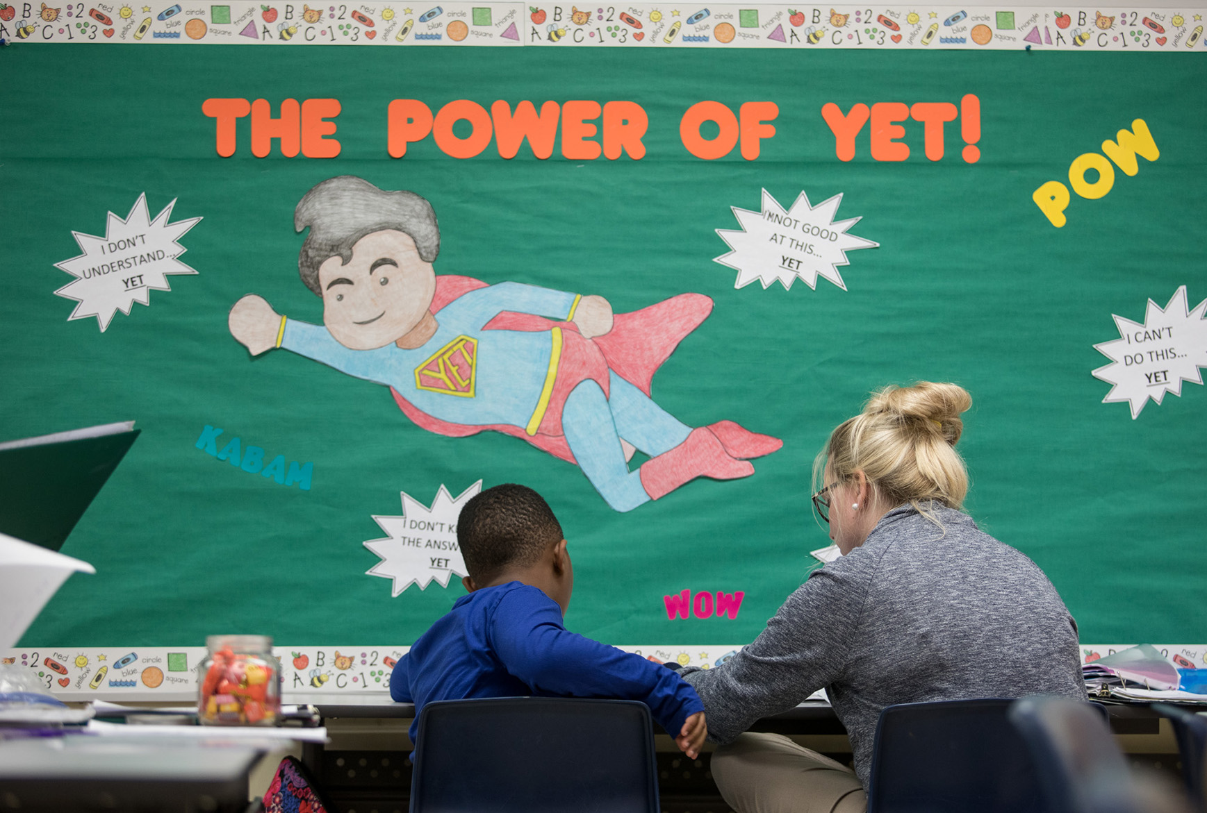 School Psychologist helping a student inside of a school classroom. 