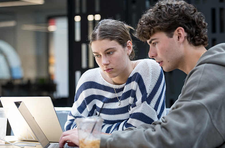 Two students studying in a classroom space