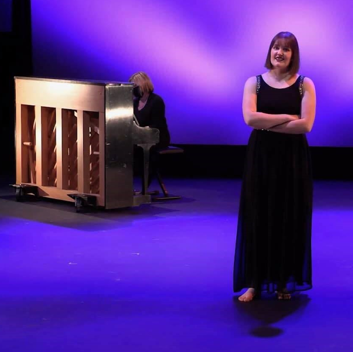 Woman on stage with painist.